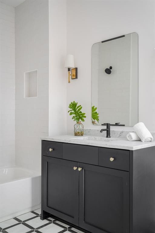 bathroom featuring tiled shower / bath combo, vanity, and tile flooring