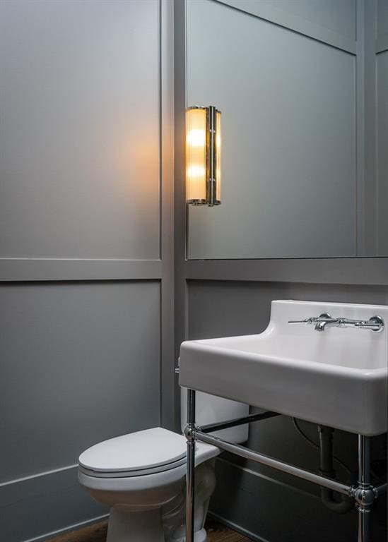 bathroom with toilet and hardwood / wood-style flooring