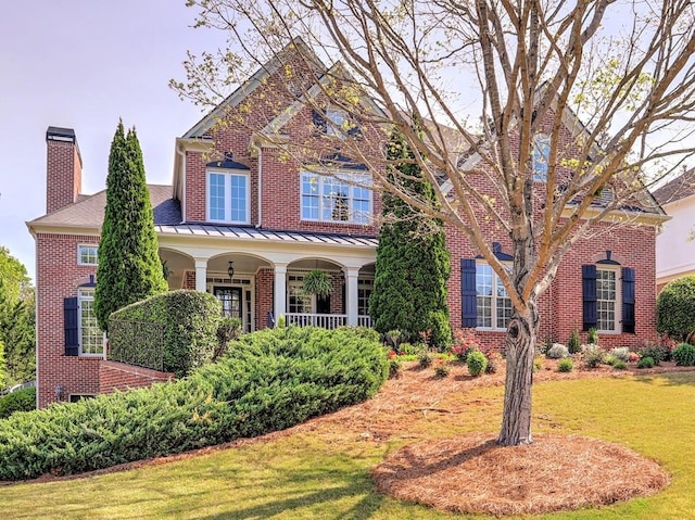 view of front of property with a porch and a front lawn