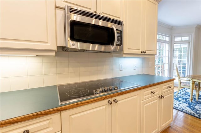 54 Old Fuller Mill Road Ne, Marietta, GA 30067 - kitchen with crown molding, tasteful backsplash, black electric stovetop, white cabinets, and light wood-type flooring