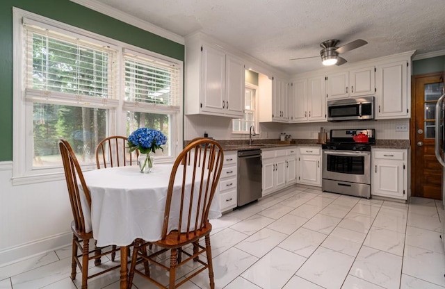 kitchen featuring white cabinets, ceiling fan, light tile flooring, and stainless steel appliances