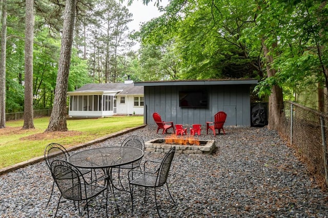 view of patio featuring a fire pit and a sunroom