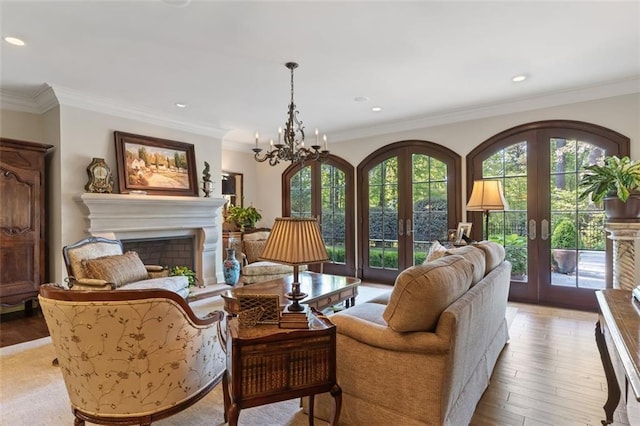 sitting room with plenty of natural light, a chandelier, french doors, and light hardwood / wood-style flooring