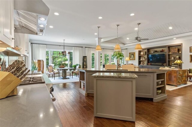 kitchen featuring ceiling fan, dark hardwood / wood-style floors, a kitchen island, and a healthy amount of sunlight