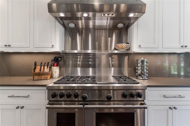 kitchen featuring backsplash, white cabinetry, and double oven range