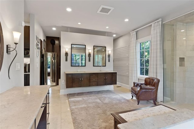 bathroom featuring tile floors, vanity, and a shower with shower door