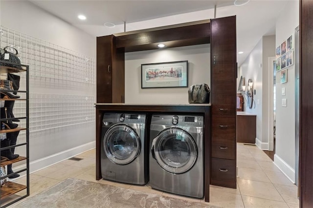 laundry area with washing machine and clothes dryer and light tile flooring