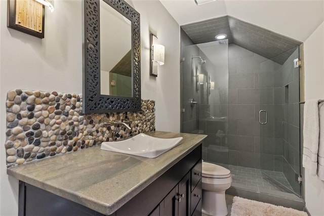 bathroom with toilet, vanity, tasteful backsplash, and a shower with door