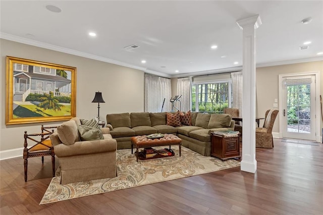 living room with a wealth of natural light, dark wood-type flooring, and ornate columns