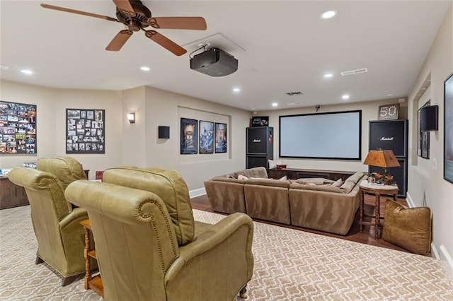 carpeted home theater room with ceiling fan