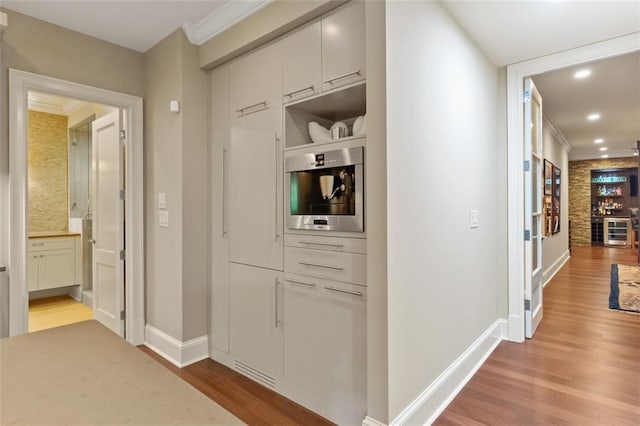 corridor featuring crown molding and light wood-type flooring