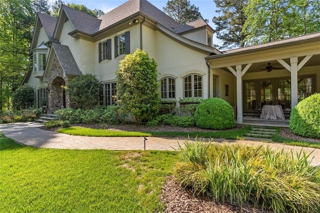 rear view of house with a lawn and ceiling fan