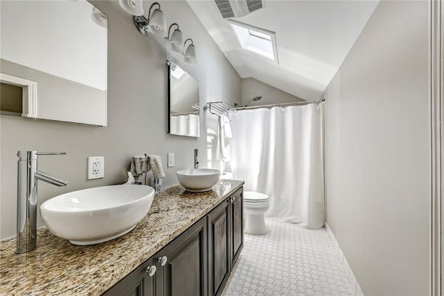 3248 W Shadowlawn Avenue Ne, Atlanta, GA 30305 - bathroom featuring lofted ceiling with skylight, double vanity, tile floors, and toilet