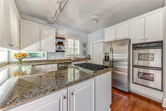 3248 W Shadowlawn Avenue Ne, Atlanta, GA 30305 - kitchen with stainless steel appliances, rail lighting, white cabinets, dark stone countertops, and dark hardwood / wood-style floors