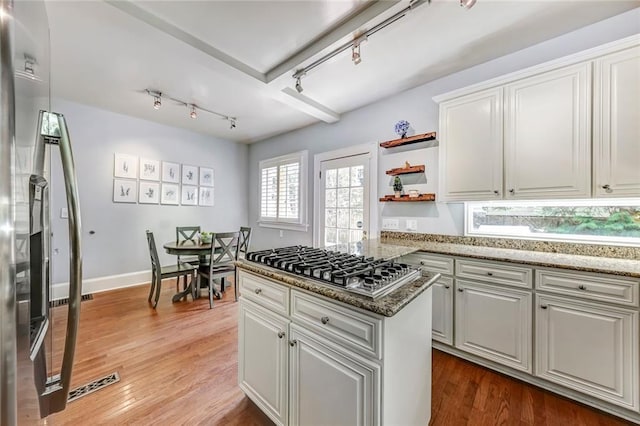3248 W Shadowlawn Avenue Ne, Atlanta, GA 30305 - kitchen featuring a center island, light stone countertops, rail lighting, hardwood / wood-style floors, and white cabinets