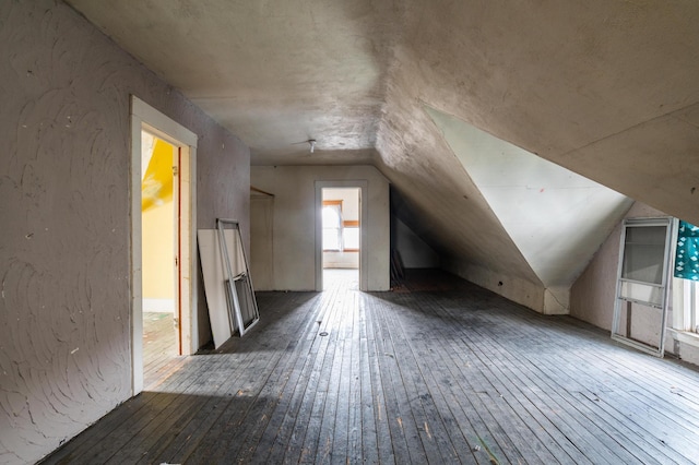 bonus room featuring dark wood-type flooring and vaulted ceiling