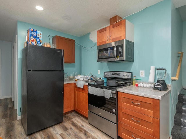 kitchen with appliances with stainless steel finishes and wood-type flooring