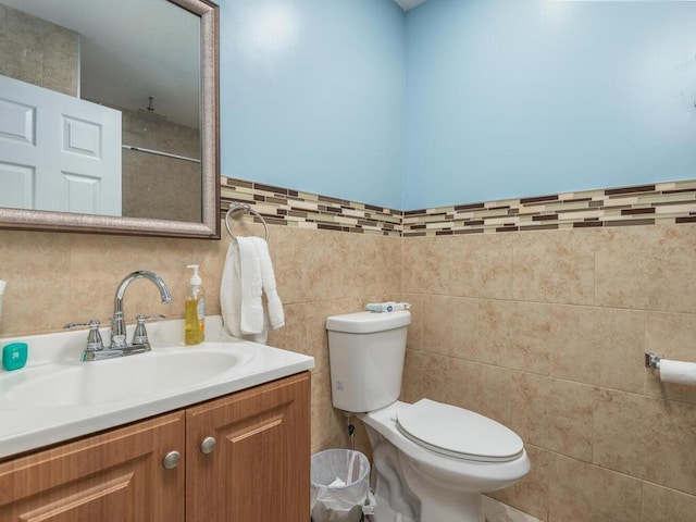 bathroom featuring backsplash, toilet, large vanity, and tile walls