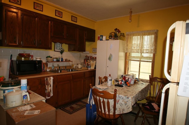 kitchen featuring sink, backsplash, and white refrigerator