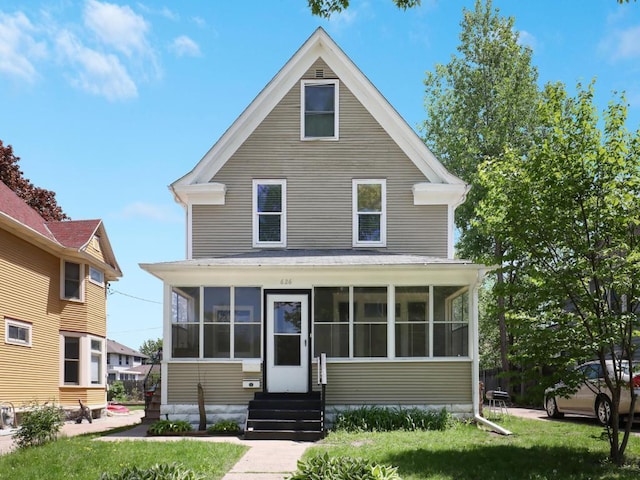 view of front property featuring a front yard and a sunroom