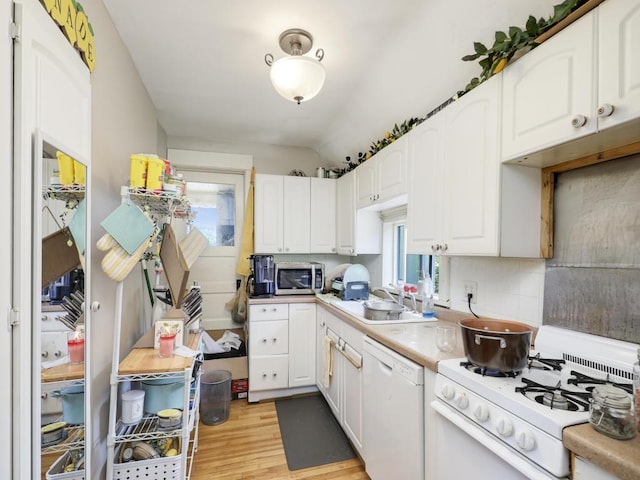 kitchen featuring white cabinets, light hardwood / wood-style flooring, tasteful backsplash, and white appliances