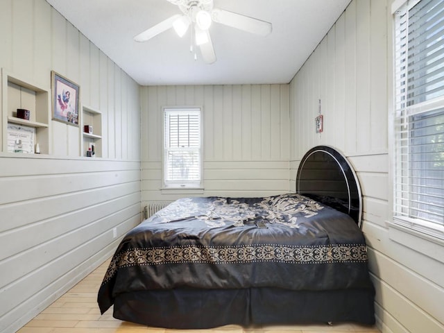 bedroom featuring radiator heating unit, ceiling fan, and light hardwood / wood-style floors