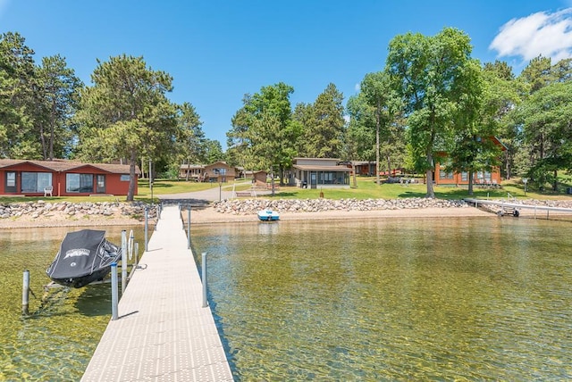 dock area with a water view and a lawn