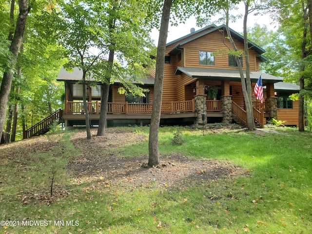 rear view of property featuring a lawn