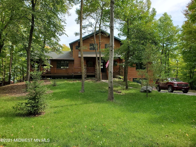 log home featuring a front lawn and a deck