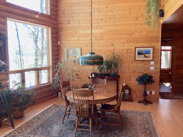 dining space with wood walls and wood-type flooring