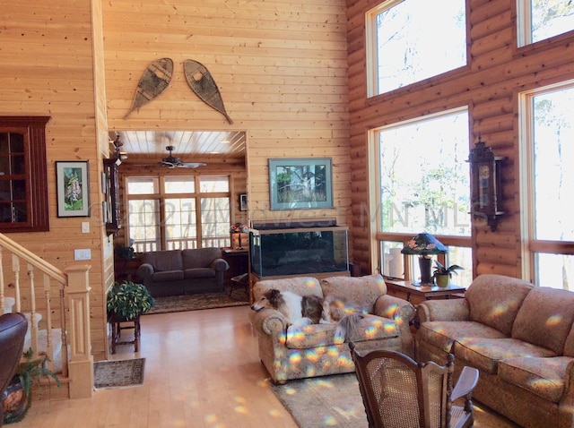 24557 Walden Rd, Rochert, MN 56578 - living area with a wealth of natural light, rustic walls, a towering ceiling, hardwood / wood-style flooring, and a fireplace