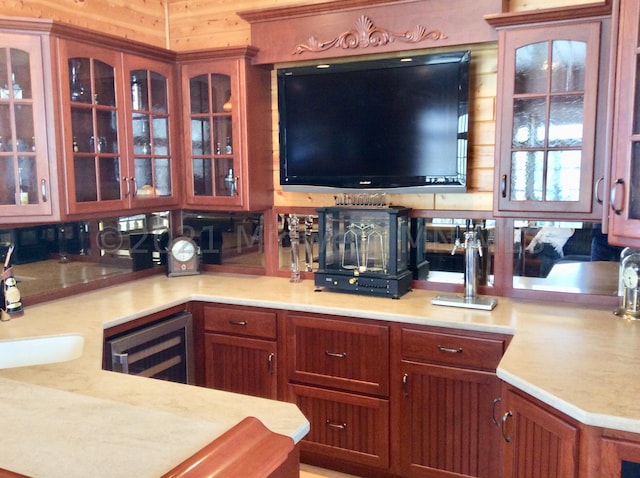 kitchen featuring wine cooler, sink, and wooden walls