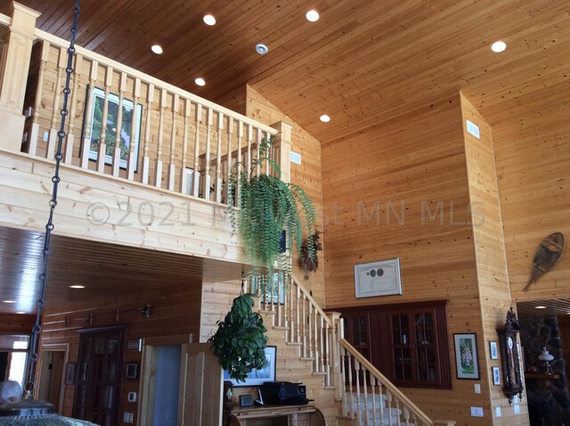 24557 Walden Rd, Rochert, MN 56578 - living room with wooden walls, a high ceiling, wooden ceiling, and stairs