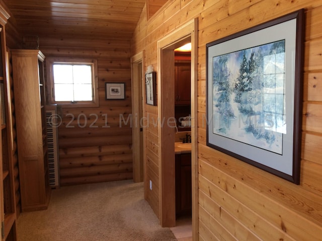 hallway featuring light carpet, wooden ceiling, and vaulted ceiling