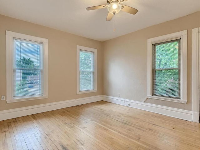 empty room featuring light hardwood / wood-style floors, ceiling fan, and a wealth of natural light