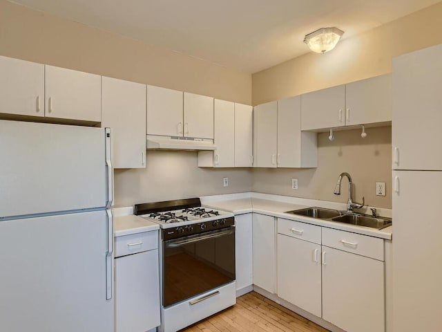 kitchen with sink, white appliances, white cabinetry, and light hardwood / wood-style floors