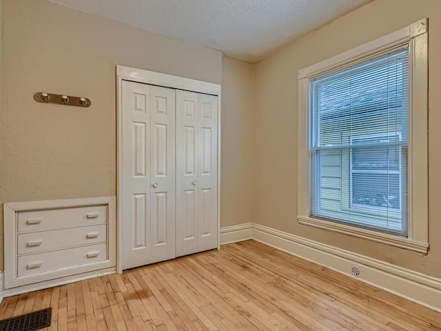 unfurnished bedroom featuring a closet and light wood-type flooring