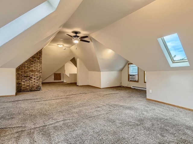 bonus room with light colored carpet, a baseboard heating unit, brick wall, ceiling fan, and lofted ceiling with skylight