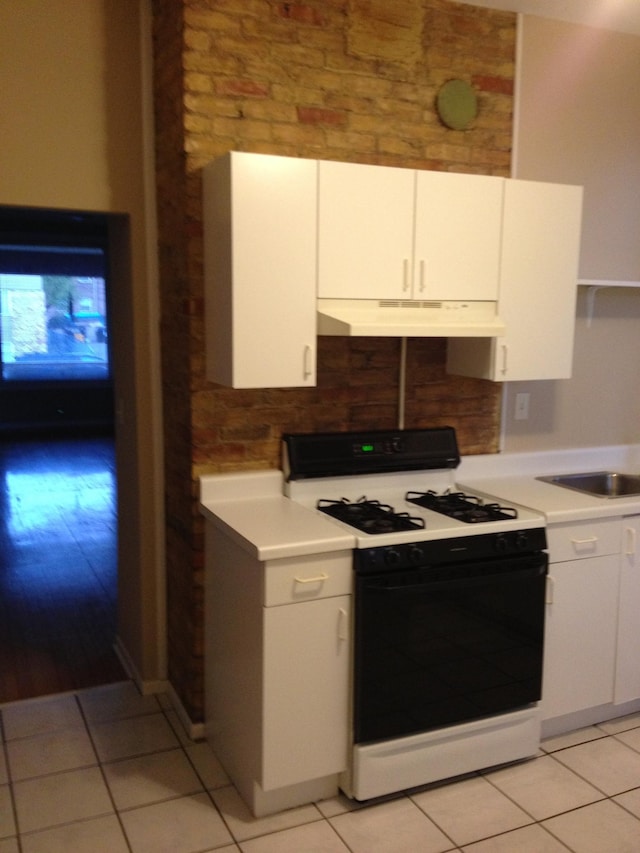 kitchen featuring white cabinets, light wood-type flooring, gas range gas stove, and sink