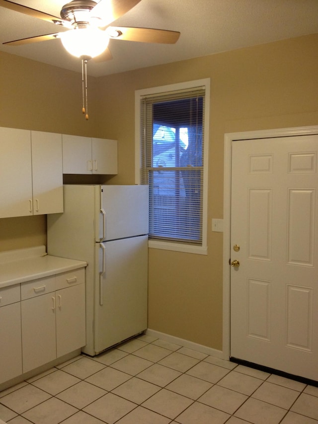 kitchen featuring ceiling fan, white cabinetry, light tile flooring, and white fridge