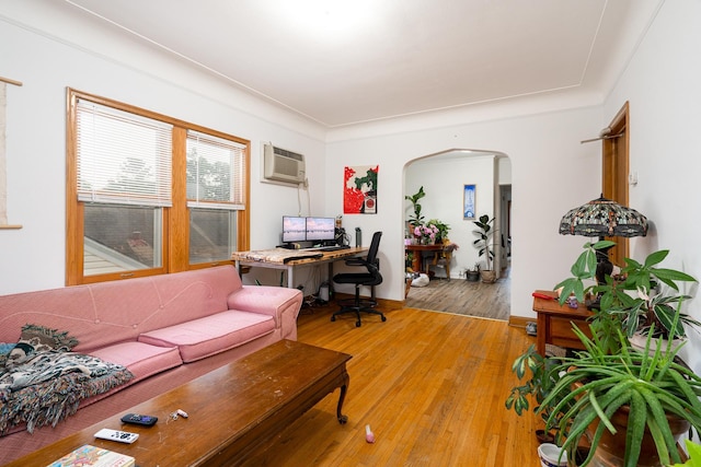 living room featuring hardwood / wood-style flooring and a wall unit AC