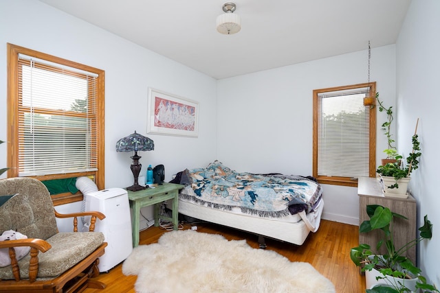 bedroom featuring multiple windows and light wood-type flooring