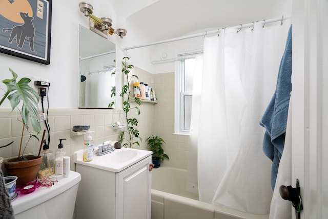 full bathroom featuring vanity, shower / tub combo with curtain, tile walls, toilet, and tasteful backsplash