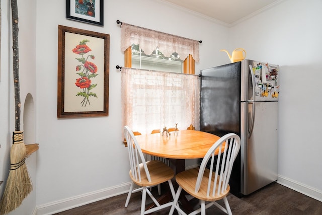 dining space featuring ornamental molding and dark wood-type flooring