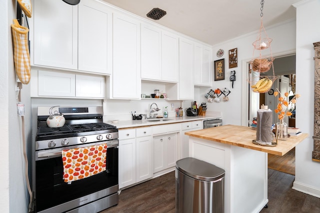 kitchen featuring butcher block counters, appliances with stainless steel finishes, and white cabinetry