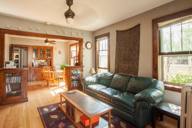 living room with light hardwood / wood-style floors and ceiling fan