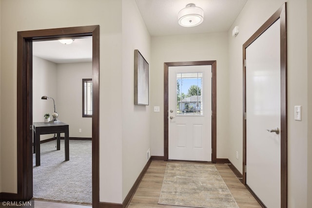 doorway to outside featuring light colored carpet