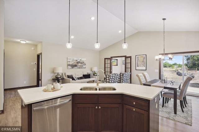 kitchen featuring light hardwood / wood-style floors, stainless steel dishwasher, sink, lofted ceiling, and hanging light fixtures