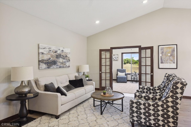 living room featuring vaulted ceiling, light wood-type flooring, and french doors