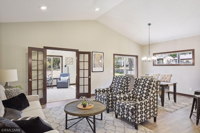 carpeted living room with high vaulted ceiling, a chandelier, and french doors